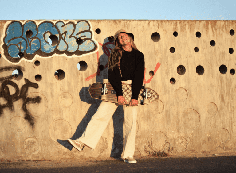 smiling girl holding a surfskate