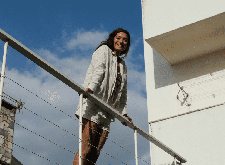 smiling girl standing on a balcony