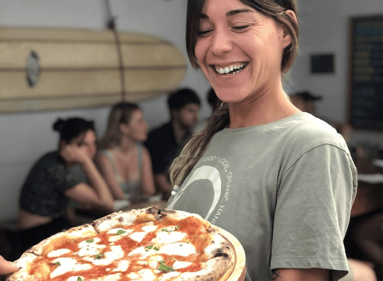 girl holding a fresh neapolitan pizza at pizza night