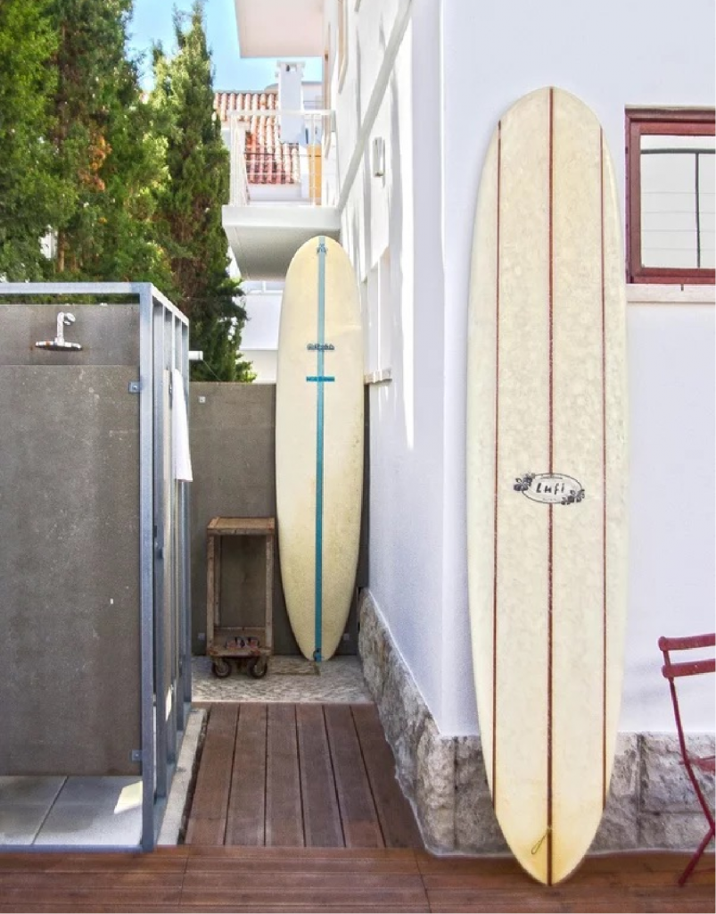 two surfboards leaning against the walls and the outdoor shower