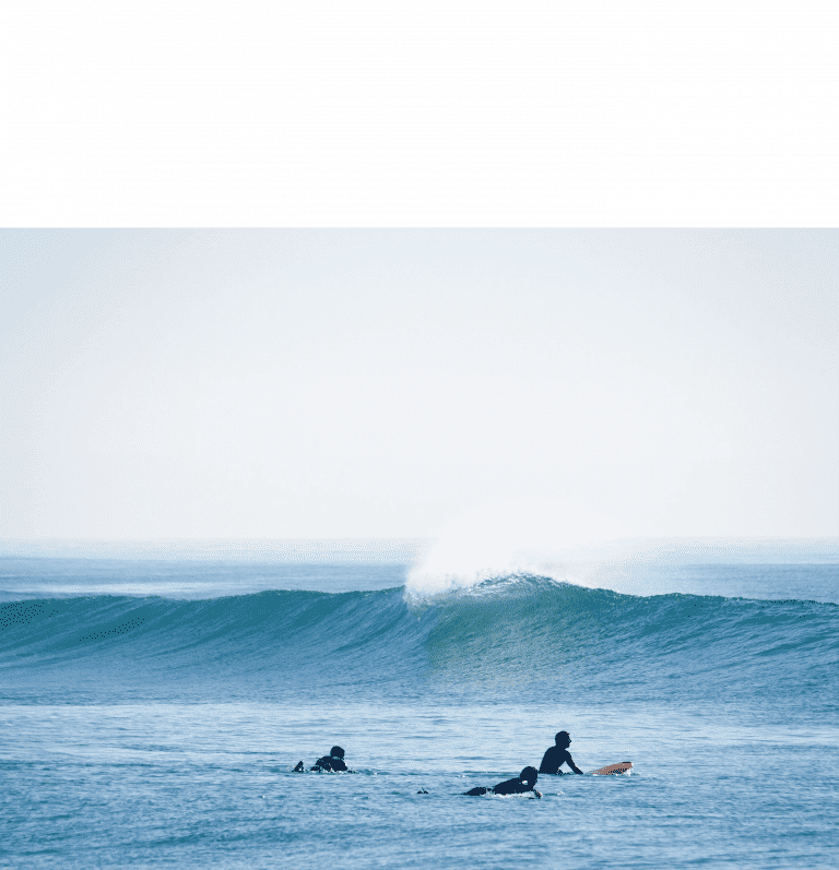 ocean wave with three surfers